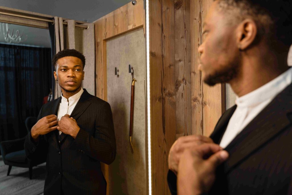 A well dressed man looking at himself in a mirror