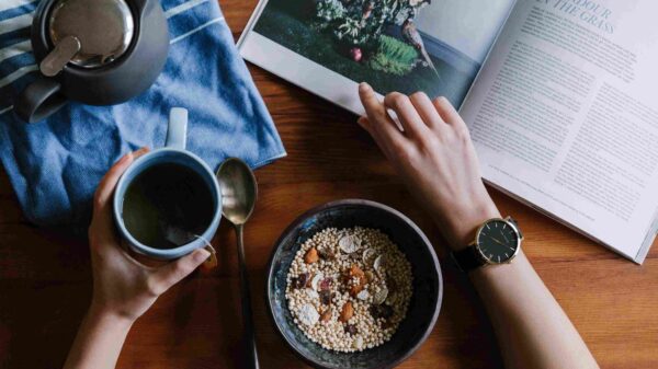 A person wearing a beautiful black watch holding a coffee mug