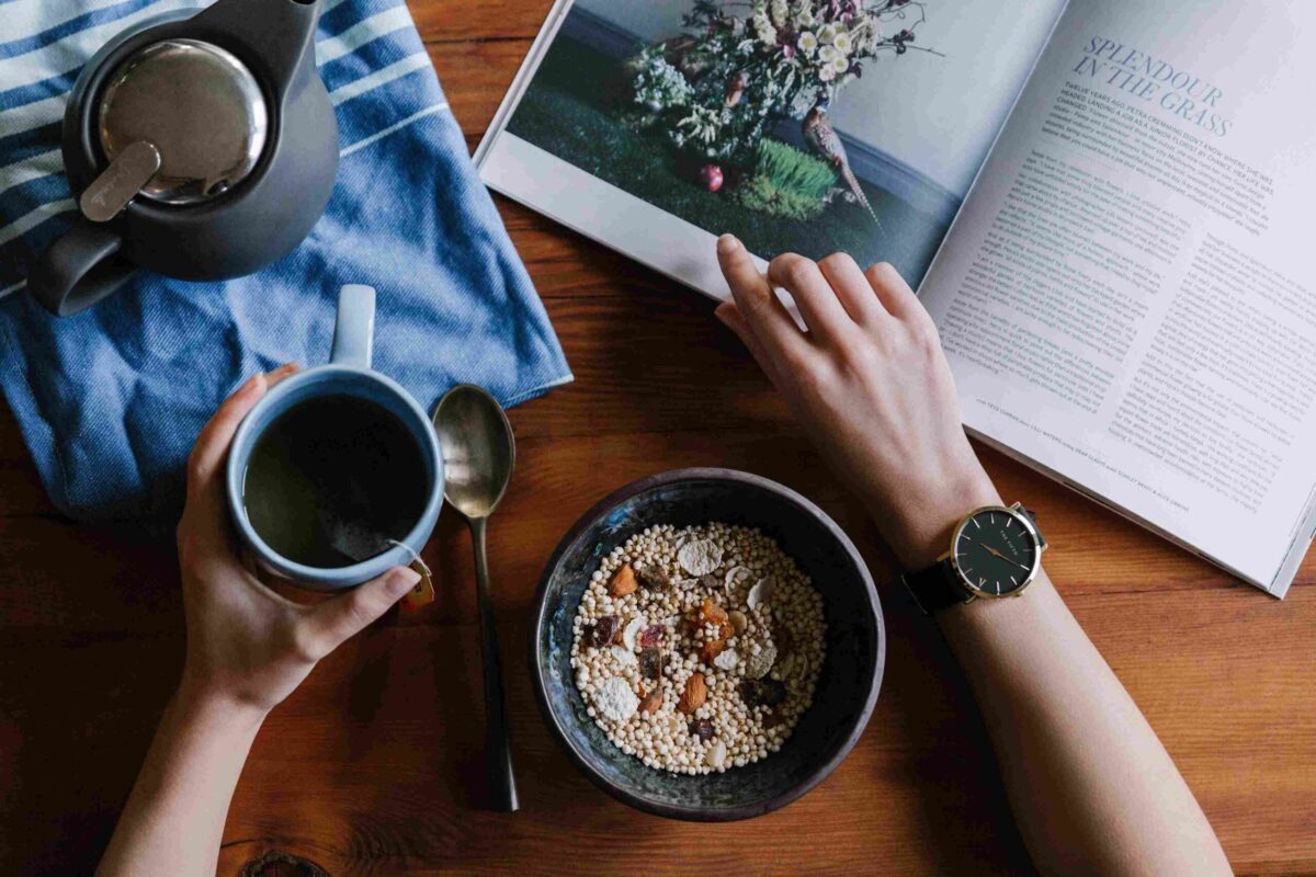 A person wearing a beautiful black watch holding a coffee mug