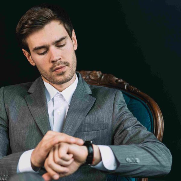 A man looking at his black classy executive watch