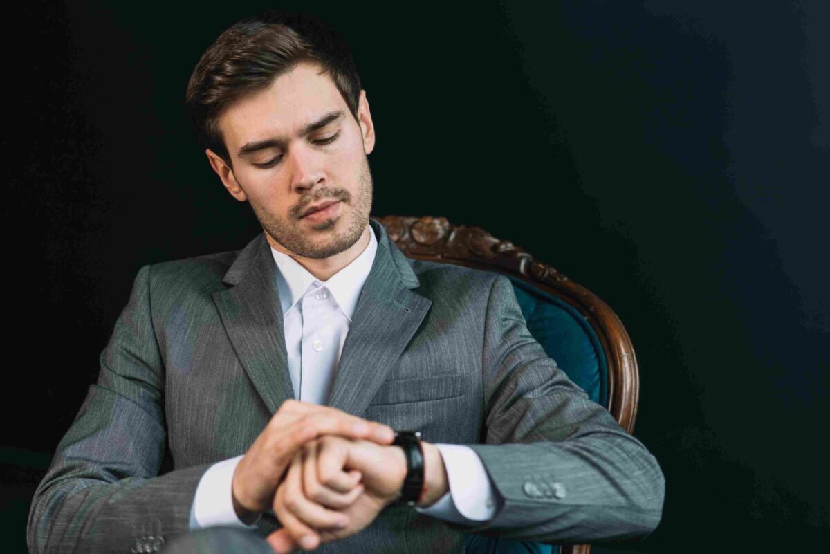 A man looking at his black classy executive watch