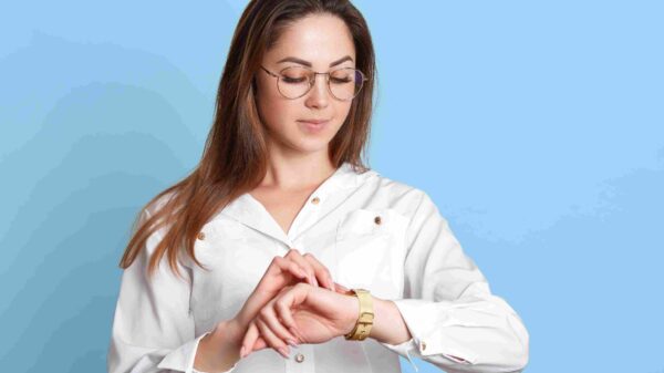 A woman looking carefully at her gold watch